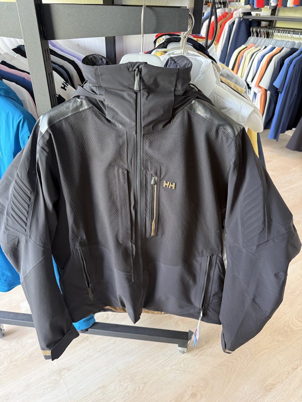 Tmavá technická bunda Helly Hansen na ramienku s kapucňou a zipsami